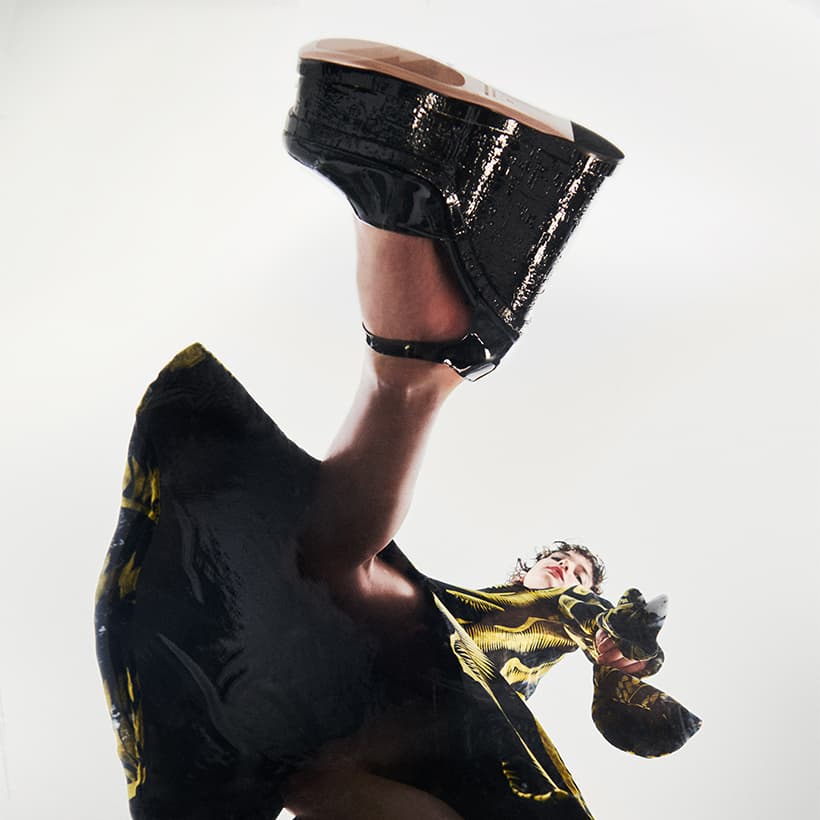 Model shot from below wearing black patent Lacquer Doll shoes