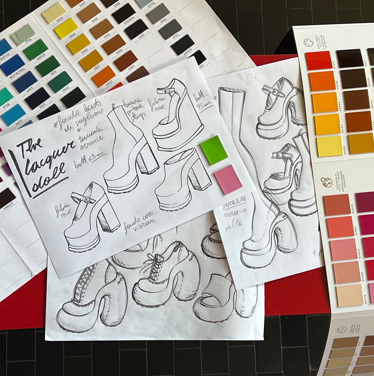 Sketches of shoe designs and color swatches lying on a table